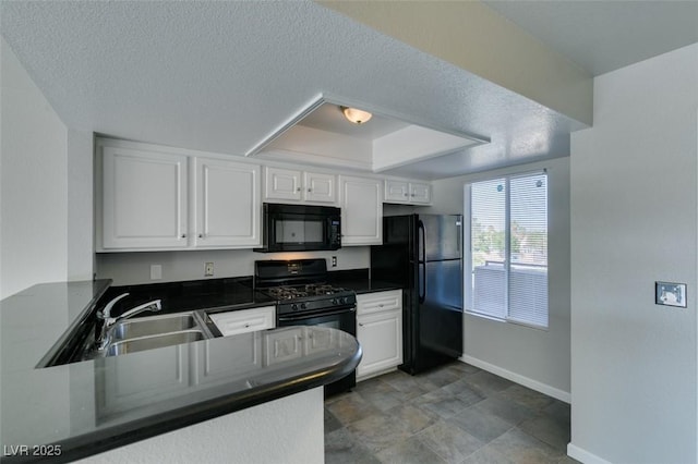 kitchen featuring baseboards, white cabinets, black appliances, and dark countertops
