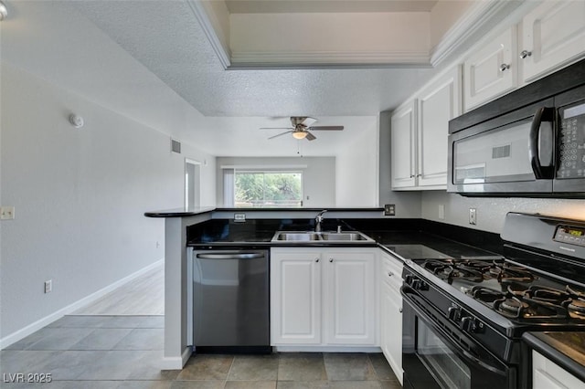 kitchen with a peninsula, dark countertops, a sink, and black appliances