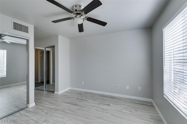 unfurnished bedroom with visible vents, a ceiling fan, light wood-style flooring, and baseboards
