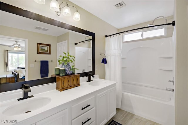 ensuite bathroom with shower / bath combo with shower curtain, visible vents, and a sink