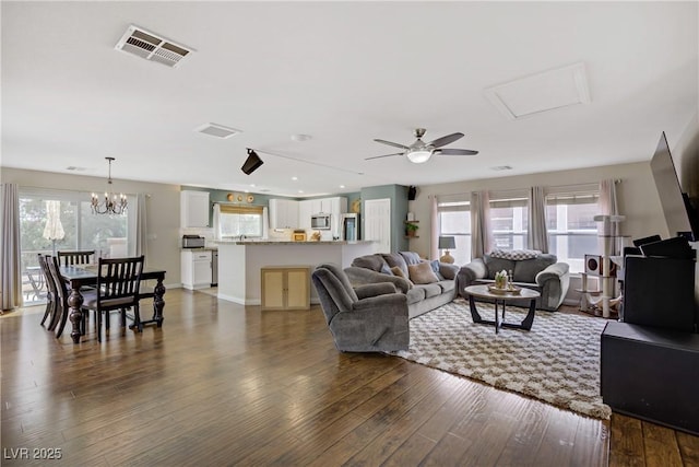 living area featuring visible vents, recessed lighting, dark wood finished floors, and ceiling fan with notable chandelier