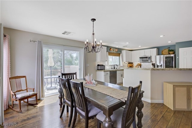 dining room featuring an inviting chandelier, recessed lighting, dark wood finished floors, and visible vents