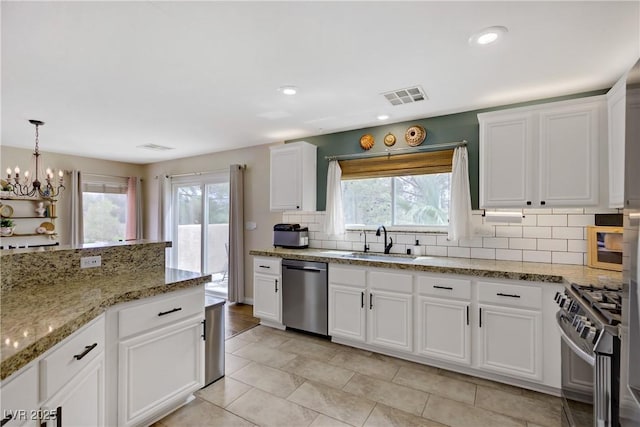 kitchen featuring an inviting chandelier, a sink, appliances with stainless steel finishes, and a healthy amount of sunlight