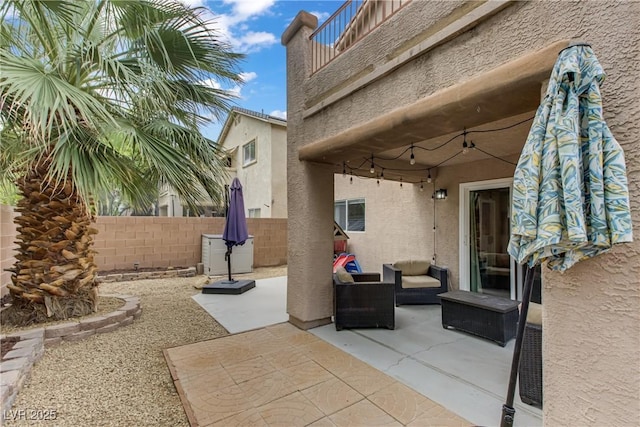view of patio with fence, an outdoor hangout area, and a balcony