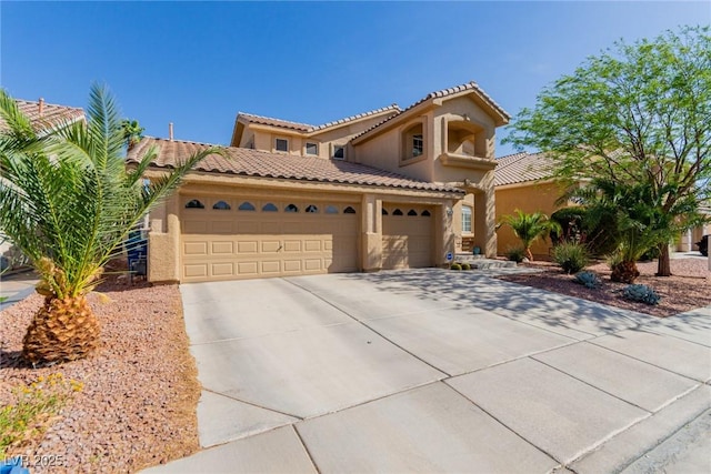 mediterranean / spanish house featuring an attached garage, driveway, a tile roof, and stucco siding
