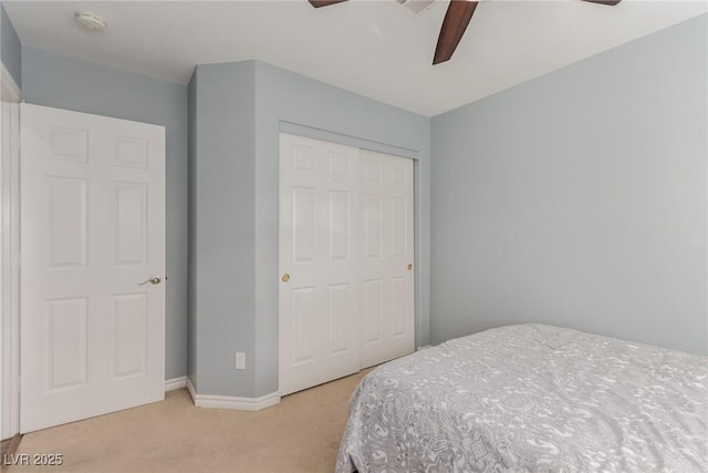 bedroom with a ceiling fan, light colored carpet, and a closet