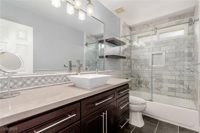 full bathroom featuring visible vents, tile patterned flooring, vanity, combined bath / shower with glass door, and toilet