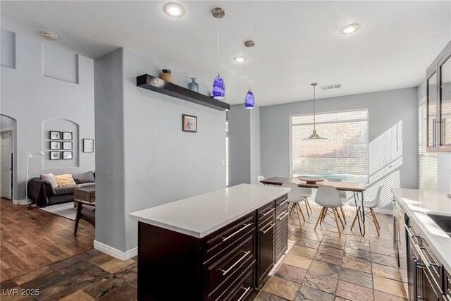 kitchen with light countertops, stone tile floors, decorative light fixtures, and baseboards