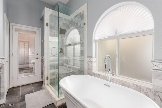 bathroom featuring a freestanding tub, marble finish floor, and a stall shower