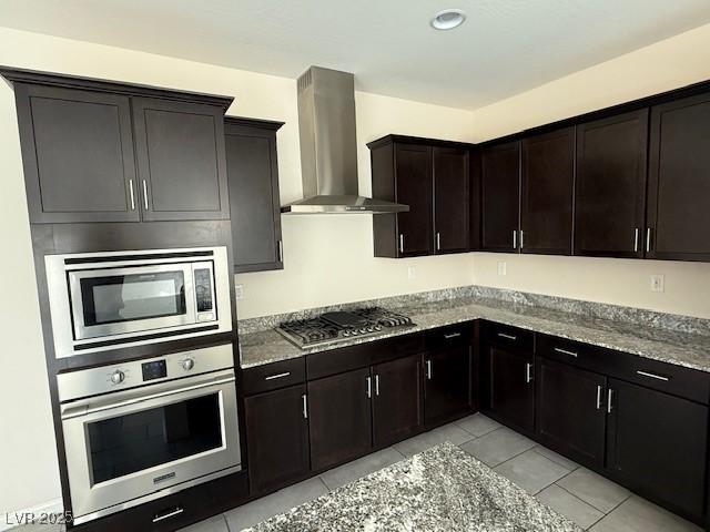 2947 Caxton Grove Dr, Henderson, NV 89052 - kitchen featuring stone countertops, appliances with stainless steel finishes, light tile patterned flooring, and wall chimney range hood