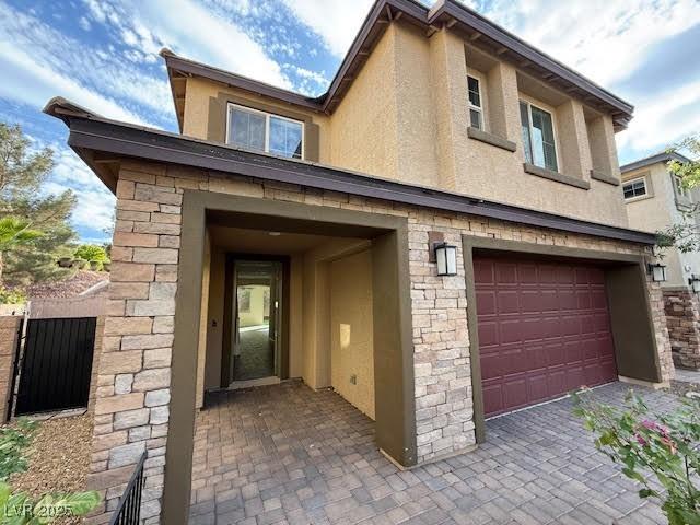 2947 Caxton Grove Dr, Henderson, NV 89052 - view of home's exterior featuring a garage, stucco siding, and stone siding