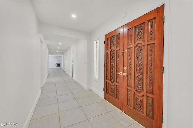 hallway featuring light tile patterned floors, baseboards, and recessed lighting