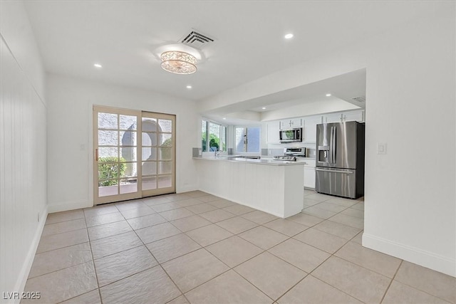 kitchen featuring recessed lighting, a peninsula, white cabinetry, and appliances with stainless steel finishes