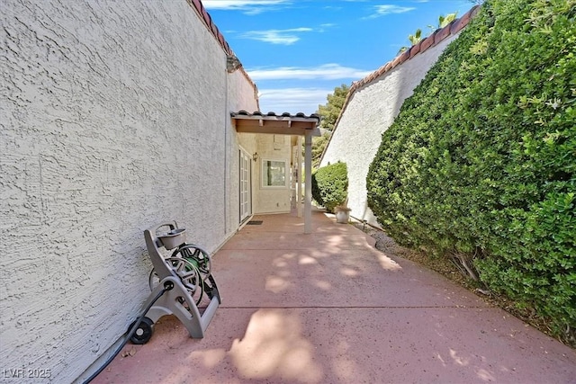view of side of property with a patio and stucco siding