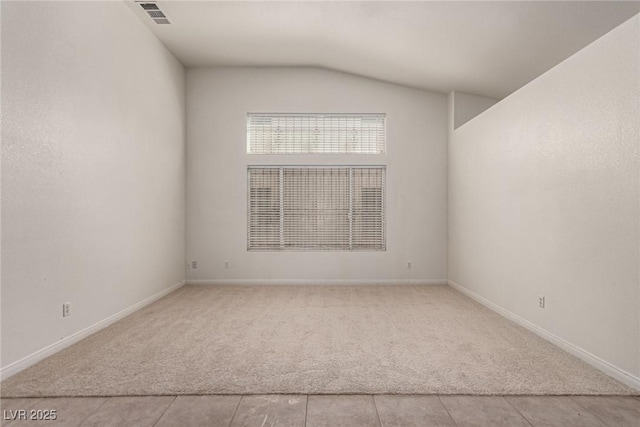 unfurnished room with baseboards, light colored carpet, lofted ceiling, and visible vents