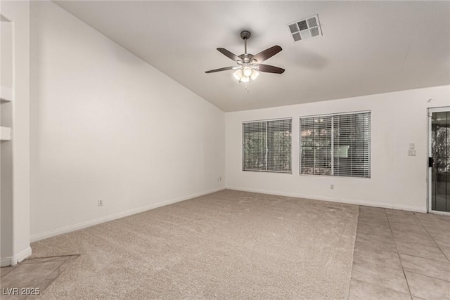empty room with a ceiling fan, visible vents, light carpet, and lofted ceiling