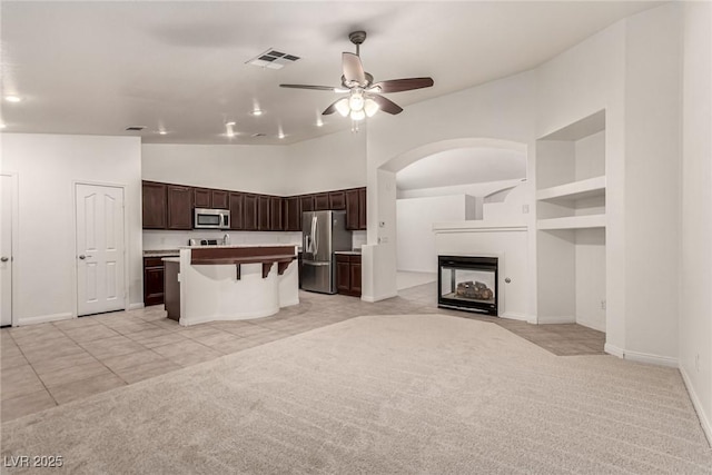 kitchen featuring a ceiling fan, visible vents, dark brown cabinets, open floor plan, and stainless steel appliances