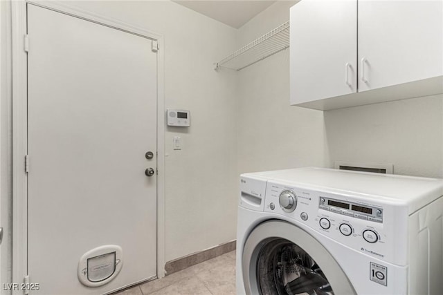 clothes washing area with baseboards, washer / dryer, cabinet space, and light tile patterned floors