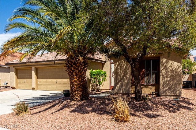 obstructed view of property with a garage, stucco siding, and concrete driveway