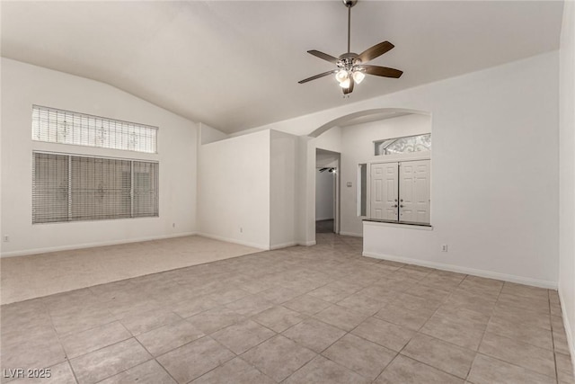 unfurnished room featuring arched walkways, light tile patterned floors, lofted ceiling, and ceiling fan