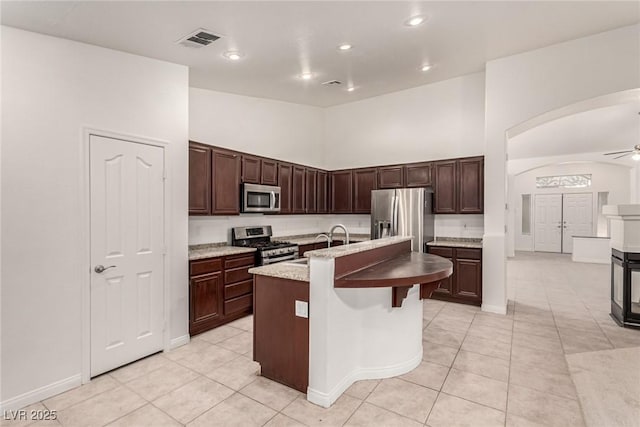 kitchen with ceiling fan, appliances with stainless steel finishes, a sink, light tile patterned floors, and visible vents