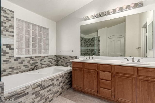 bathroom featuring double vanity, a sink, a bath, and a stall shower