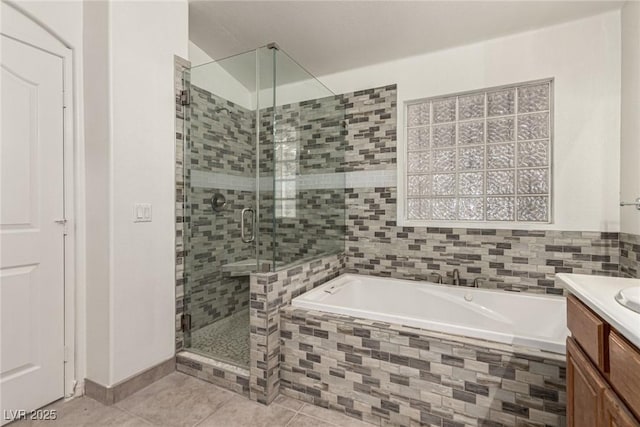full bathroom featuring vanity, tile patterned floors, a bath, and a stall shower