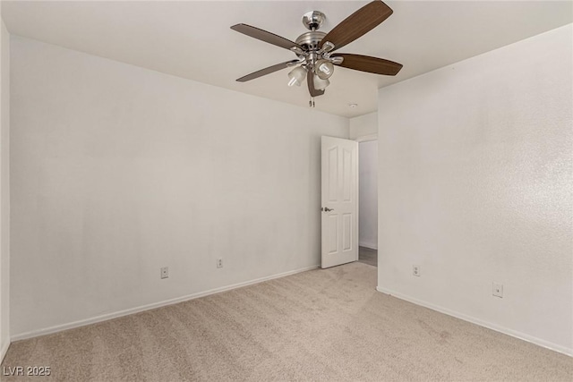 unfurnished room featuring light colored carpet, a ceiling fan, and baseboards