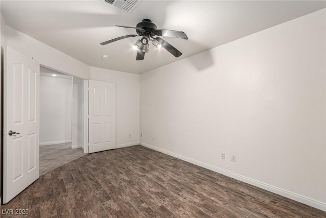 unfurnished bedroom featuring baseboards, ceiling fan, wood finished floors, and visible vents