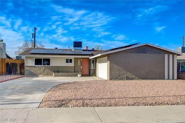 5904 Apple Valley Ln, Las Vegas, NV 89108 - view of front of house featuring roof mounted solar panels, fence, concrete driveway, a garage, and central air condition unit
