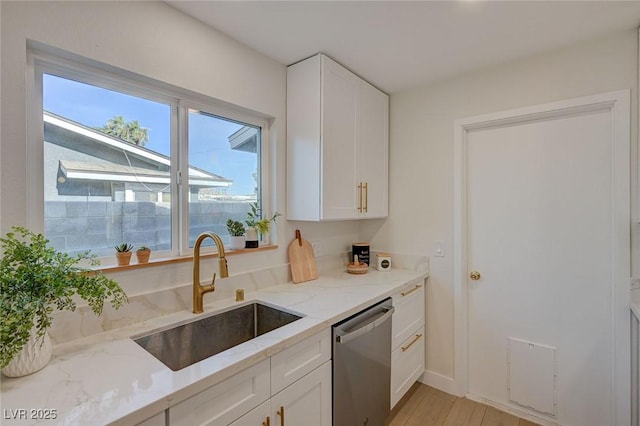 kitchen featuring a sink, white cabinets, light stone countertops, and dishwasher