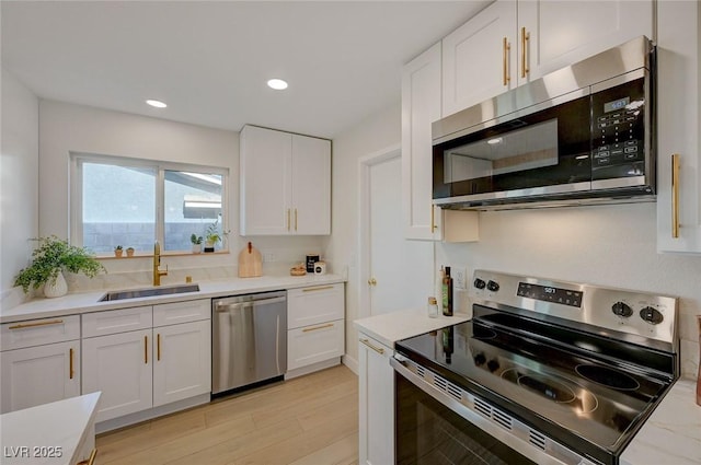 5904 Apple Valley Ln, Las Vegas, NV 89108 - kitchen with appliances with stainless steel finishes, a sink, white cabinets, light countertops, and recessed lighting