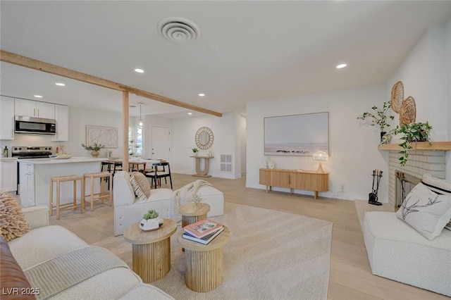 living area featuring recessed lighting, visible vents, and light wood-style floors
