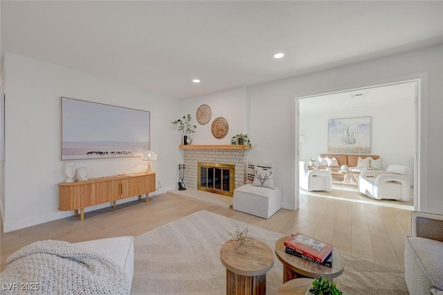 living room featuring recessed lighting, wood finished floors, and a fireplace