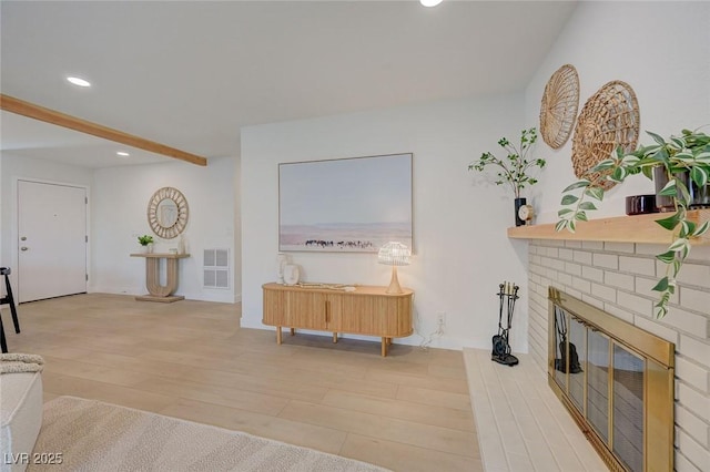 living room featuring visible vents, wood finished floors, a fireplace, beamed ceiling, and recessed lighting