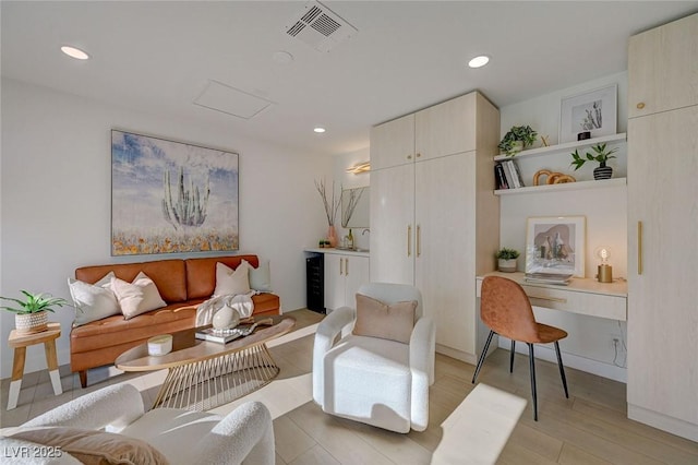 living room featuring recessed lighting, light wood-type flooring, beverage cooler, and visible vents