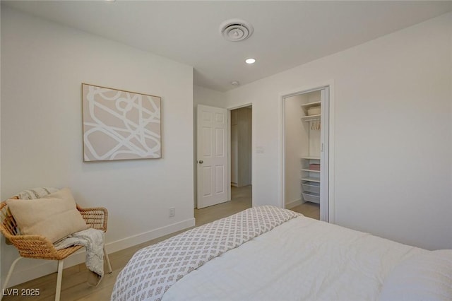 bedroom with baseboards, recessed lighting, light wood finished floors, and visible vents