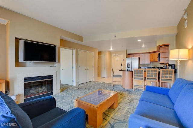 living area with recessed lighting, light carpet, and a tile fireplace