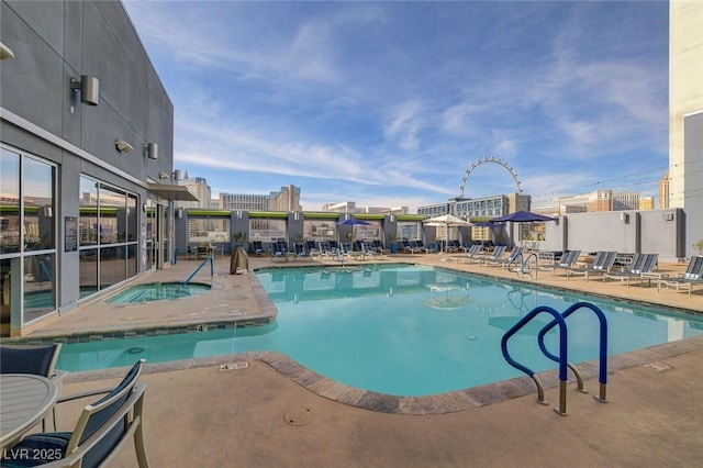 community pool featuring a community hot tub and a patio area