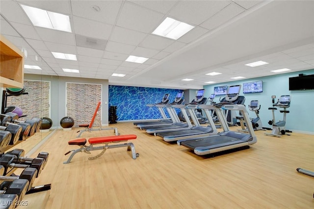 exercise room featuring a paneled ceiling and wood finished floors