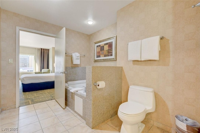 ensuite bathroom featuring a garden tub, ensuite bath, tile patterned floors, and toilet