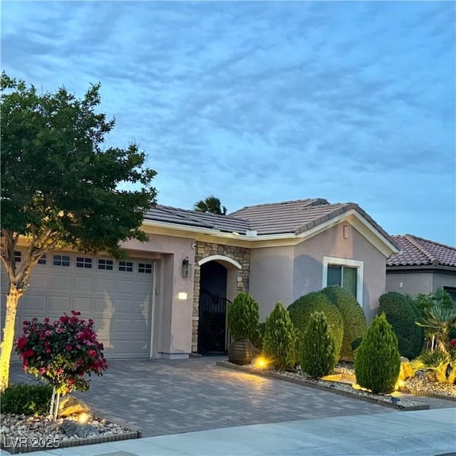 2312 Indigo Island St, Henderson, NV 89044 - ranch-style house featuring a garage, stone siding, decorative driveway, stucco siding, and a tile roof