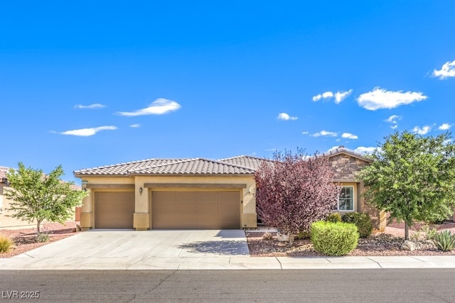 view of front of house featuring an attached garage, stucco siding, driveway, and a tile roof