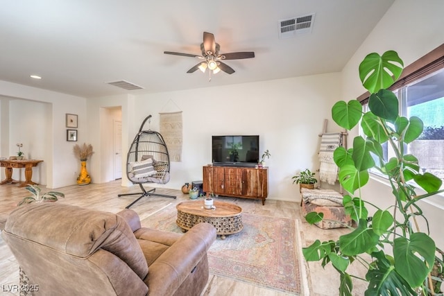 living room with ceiling fan and visible vents