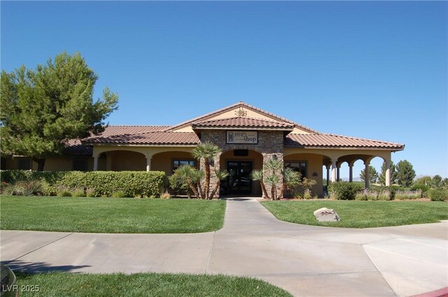 5500 E Volterra Dr, Pahrump, NV 89061 - mediterranean / spanish-style home featuring a tile roof, stone siding, a front lawn, and stucco siding