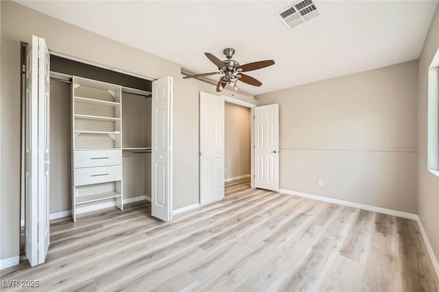 unfurnished bedroom featuring visible vents, light wood-style flooring, baseboards, and a closet