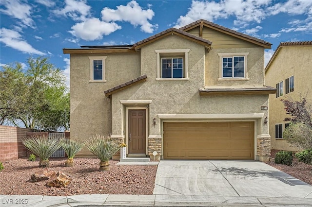 traditional-style home with driveway, fence, an attached garage, stone siding, and stucco siding