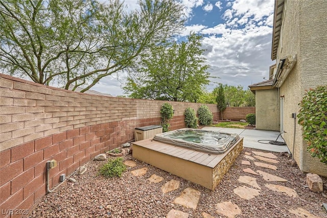 view of yard with a fenced backyard and an outdoor hot tub