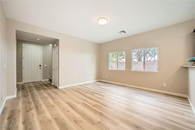 empty room featuring baseboards, visible vents, and light wood-style flooring