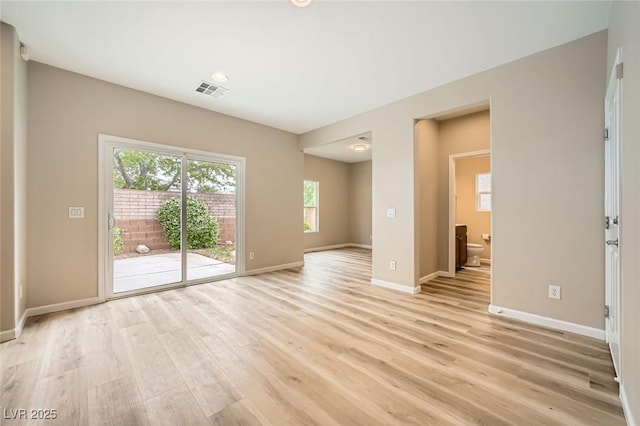 unfurnished living room featuring light wood-style floors, baseboards, and visible vents